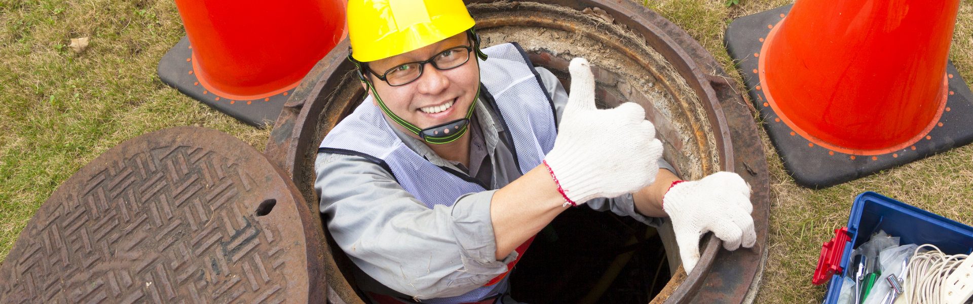man in sewage doing thumbs up